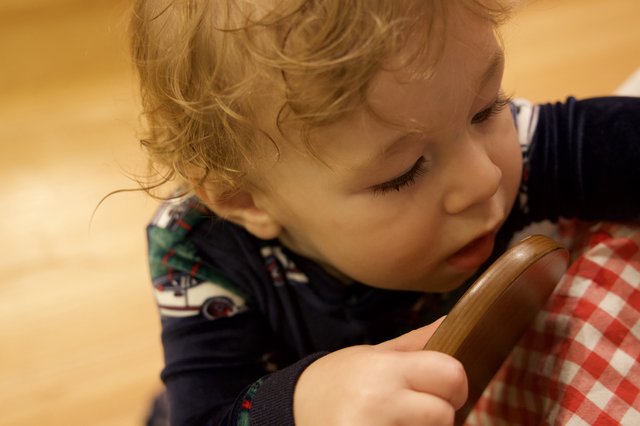 Toddler with Blonde Curls Focused on Wooden Spoon