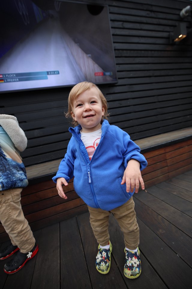 Joyful Toddler at Indoor Venue with Digital Display