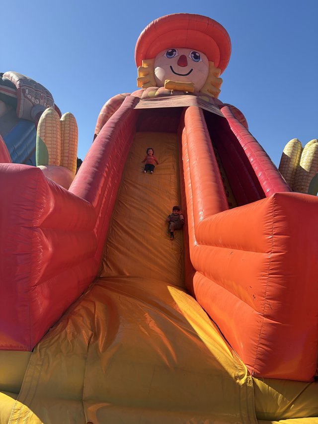 Children Sliding Down Giant Inflatable Harvest Doll