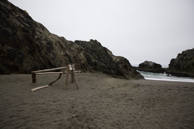 Driftwood Sculpture on Moody Coastal Cove Beach