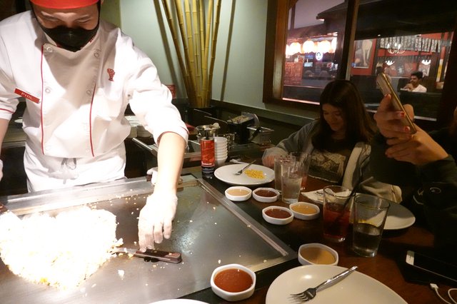Hibachi Chef Cooking for Diners at Teppanyaki Restaurant