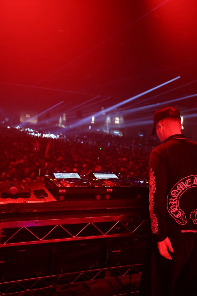 DJ Commands Massive Crowd Under Red Festival Lights