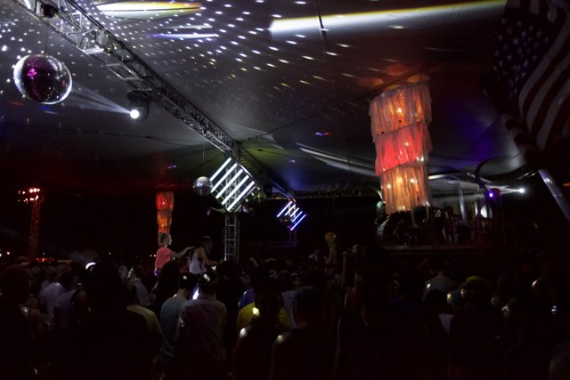 Electric Nightlife: A Crowd Dances Beneath a Swarm of Disco Balls