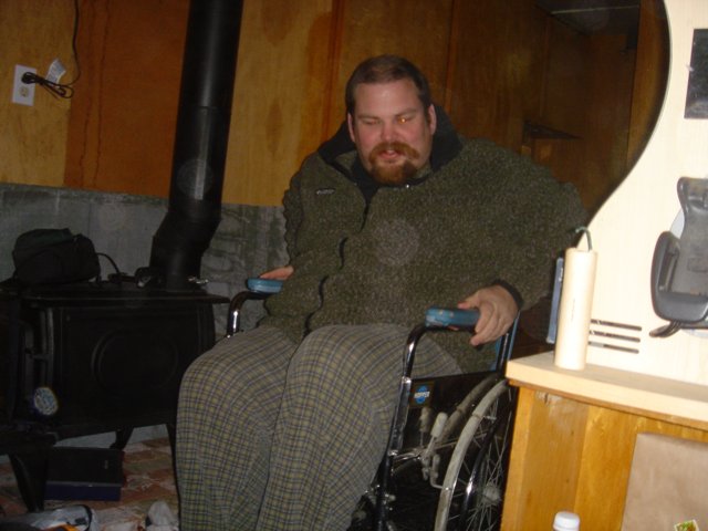 Wheelchair-bound Flea F poses with favorite armchair