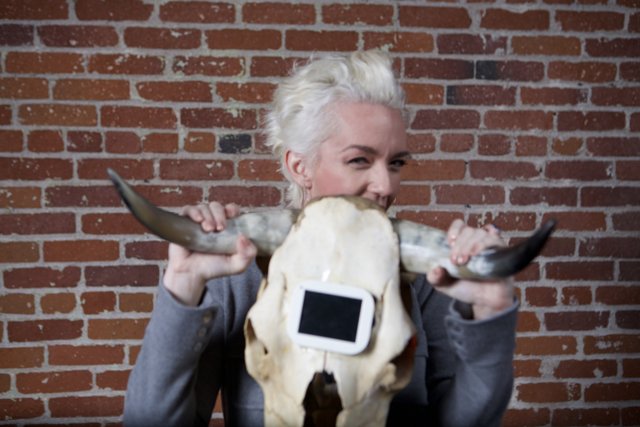 Woman poses with cow skull