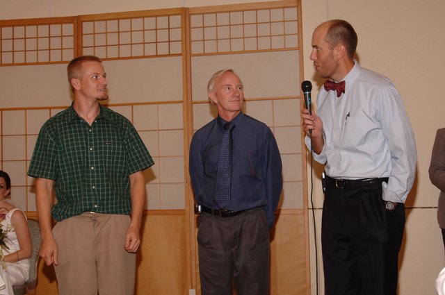 Three Men at Wedding Reception with Microphone