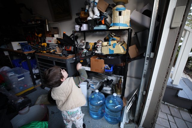 Young Child Exploring Workshop Storage Shelves