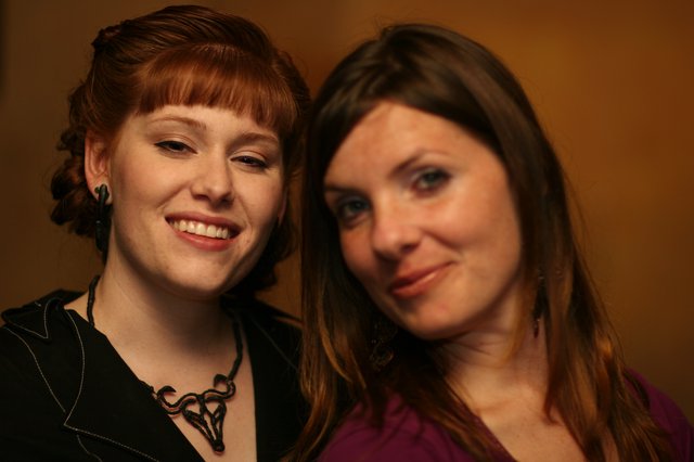 Two Women Smiling Together at Indoor Event
