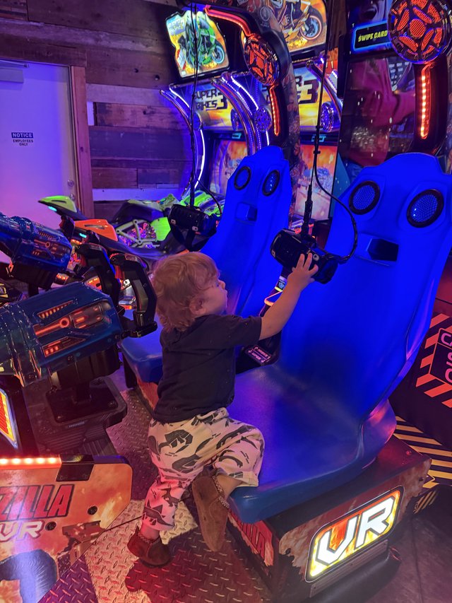 Child Playing Virtual Reality Motorcycle Racing Game in Arcade