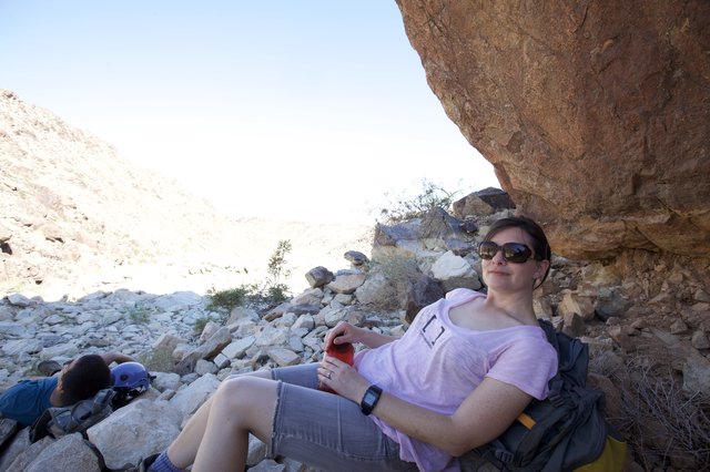 Desert Hiker Resting in the Shade of a Boulder