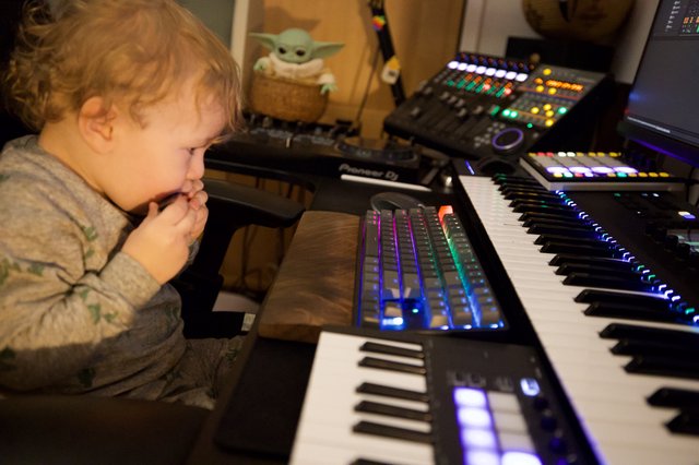 Young Child Explores Music Production Setup at Home