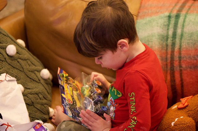 Boy Opening Action Figure Toy on Christmas Morning
