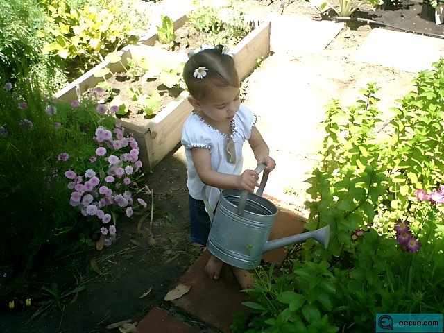 Young girl tending to her outdoor herbal garden