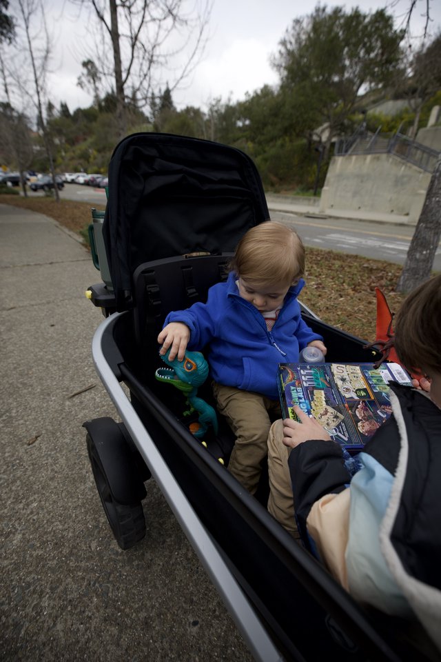 Young Children Sharing Book in Modern Stroller Outdoors