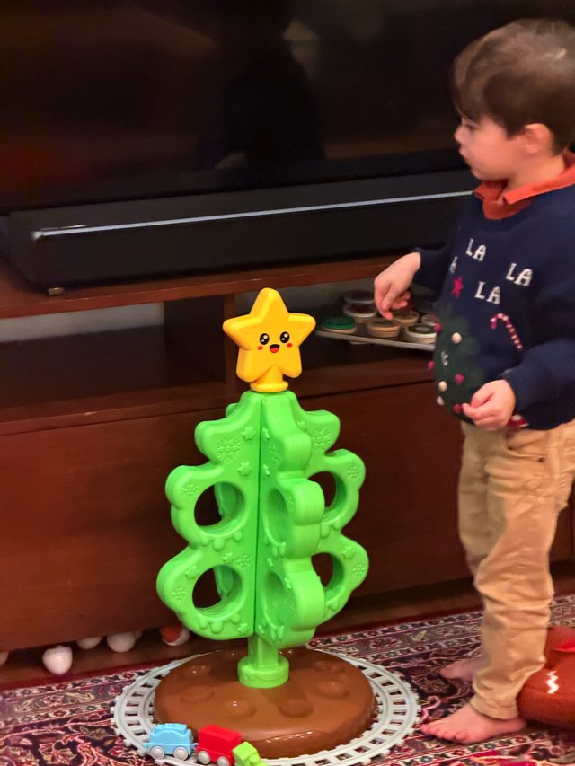 Child Playing with Christmas Tree Toy and Train Set
