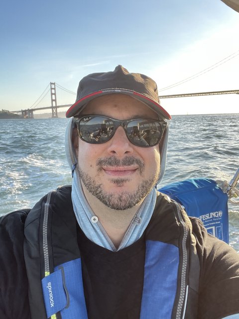 Man in Sunglasses and Hat Enjoys Scenic Boat Ride in San Francisco Bay