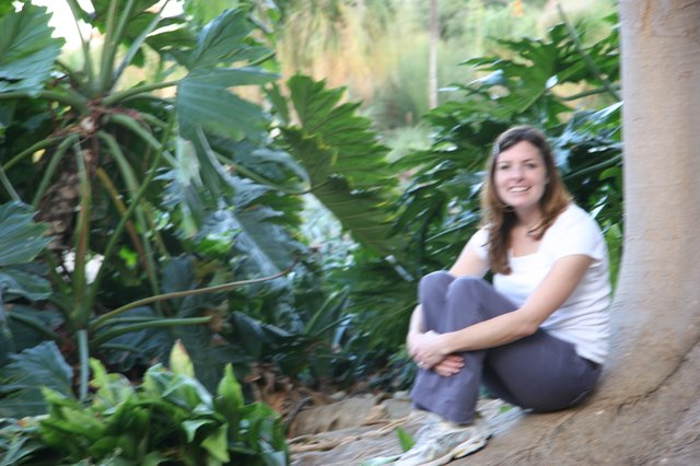 Woman Smiling Among Lush Tropical Garden Foliage