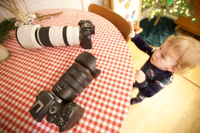 Professional Camera Gear Display with Curious Toddler Observer