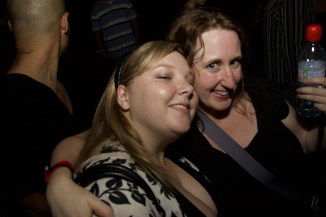 Urban Nightlife: Two Women Hugging at Club Party