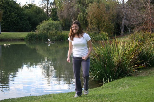 Woman Smiling by Tranquil Park Pond at Dusk