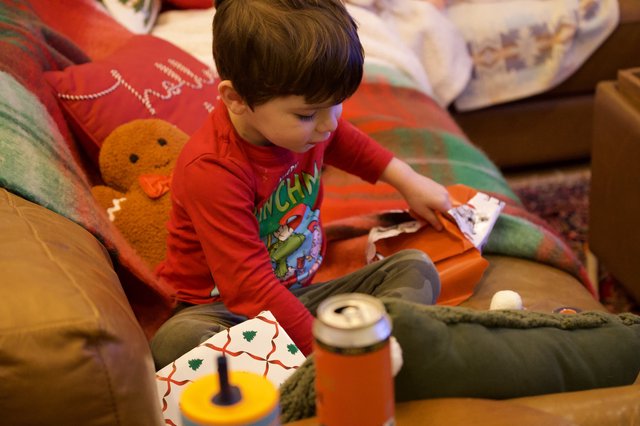 Child Opening Christmas Presents on Cozy Morning