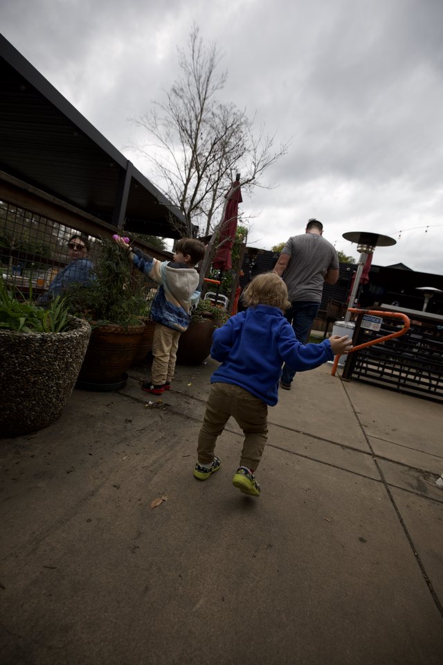 Children Playing on Restaurant Patio Under Cloudy Skies