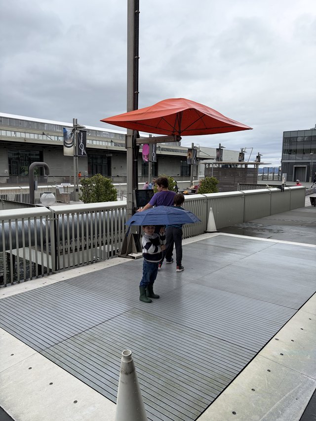 Child with Blue Umbrella on Modern Waterfront Plaza
