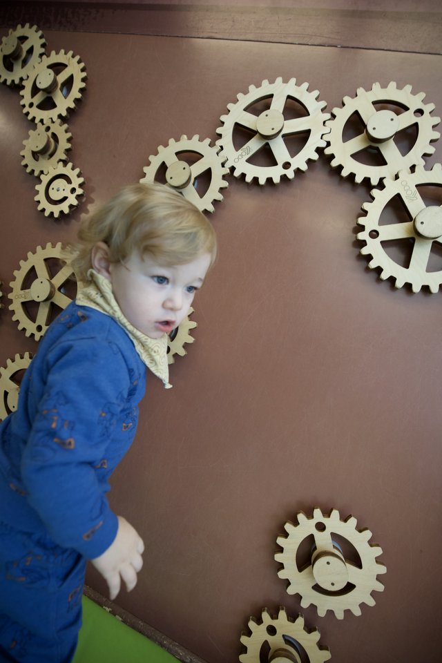 Toddler Exploring Interactive Gear Wall Display