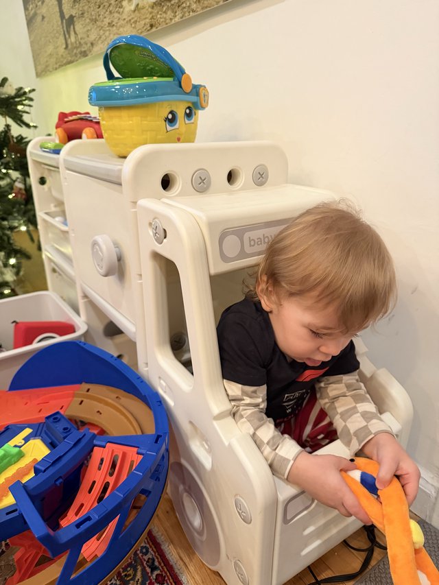 Toddler Playing with Toys in Baby Gate Enclosure