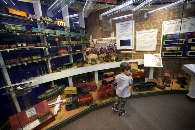 Young Boy Exploring Vintage Toy Museum Collection
