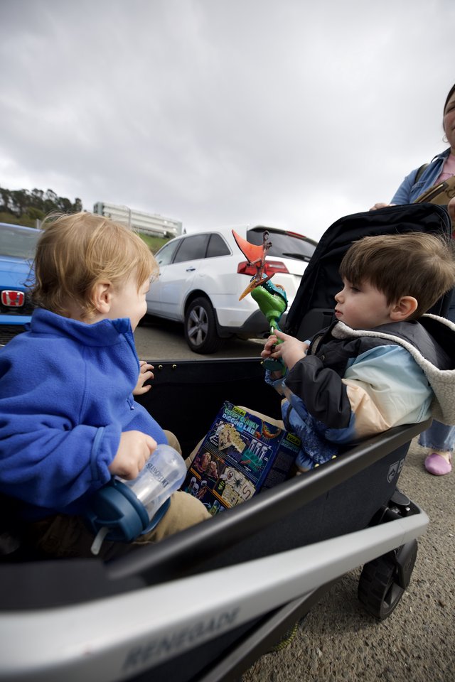 Two Young Children Sharing Moment in Parking Lot Wagon