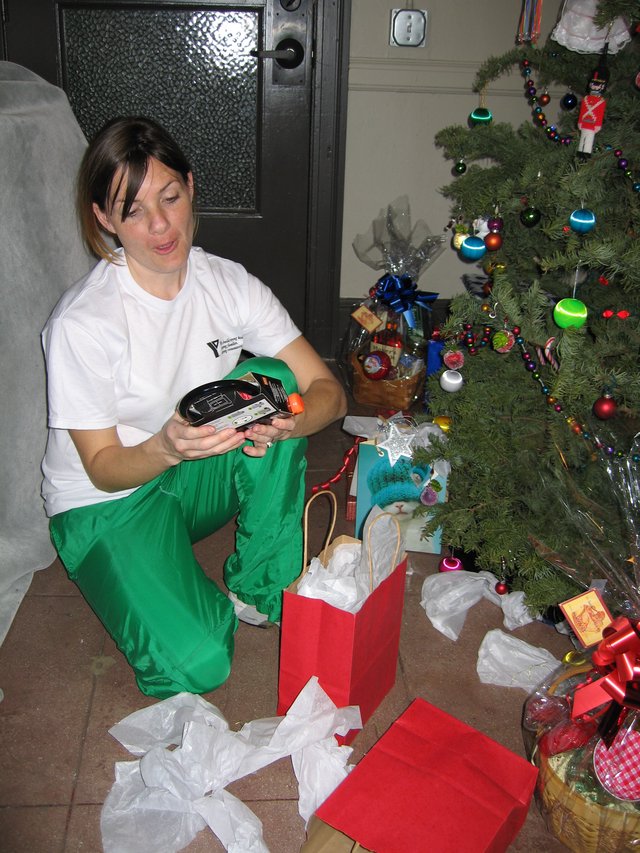 Woman Opening Christmas Gifts by Decorated Tree