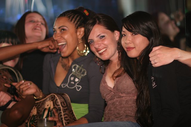 Three Friends Laughing Together at Nightclub Party