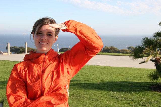 Young Woman Saluting by the Pacific Ocean