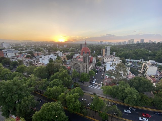 Cityscape at Sunset with Church in Background