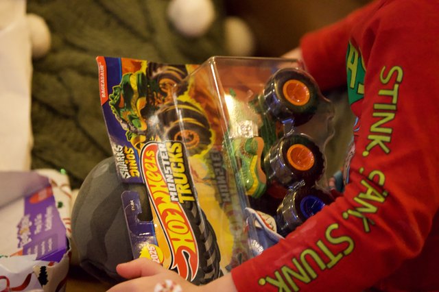 Child Opening Monster Trucks Toy on Christmas Eve