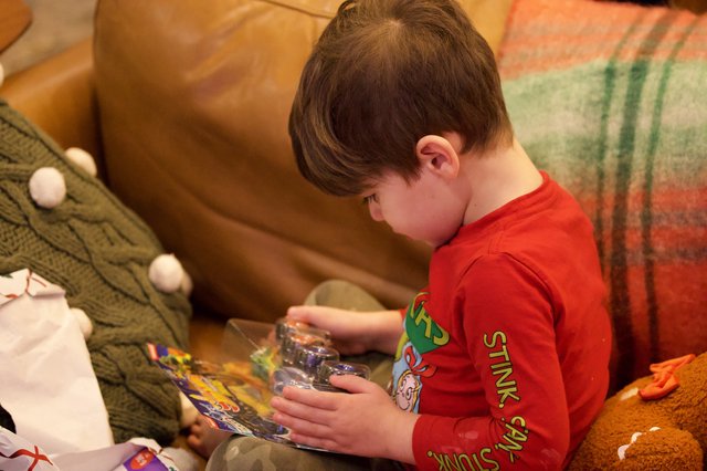 Young Boy Opening Toy on Christmas Morning
