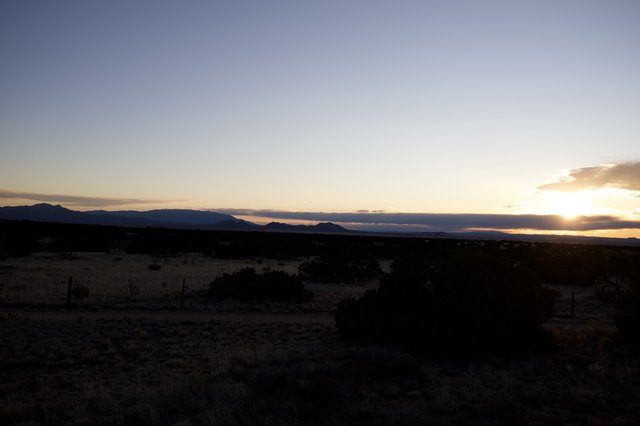 Sunset Over Mountain Silhouettes in Desert Landscape