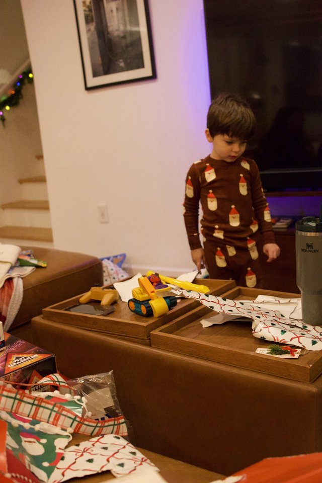 Child Opening Christmas Presents in Cozy Living Room
