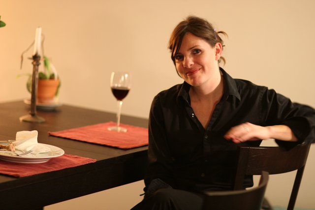 Woman Relaxing at Dinner Table with Red Wine