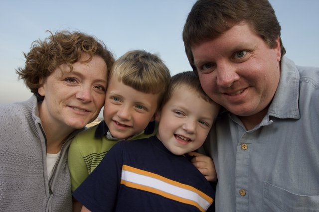 Happy Family of Four Poses Together Outdoors