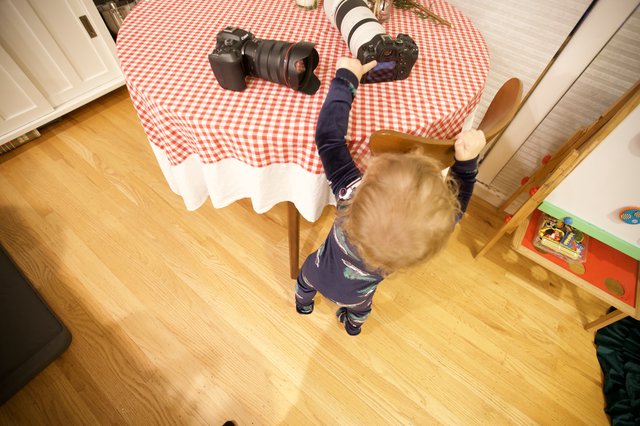 Young Child Reaching for Professional Camera Equipment