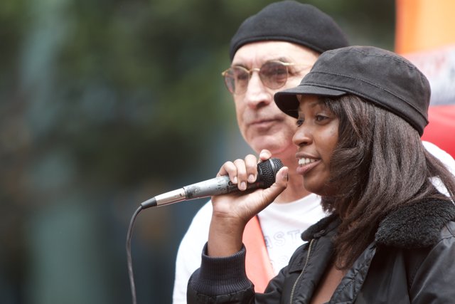 Woman in Black Jacket Performing with Microphone
