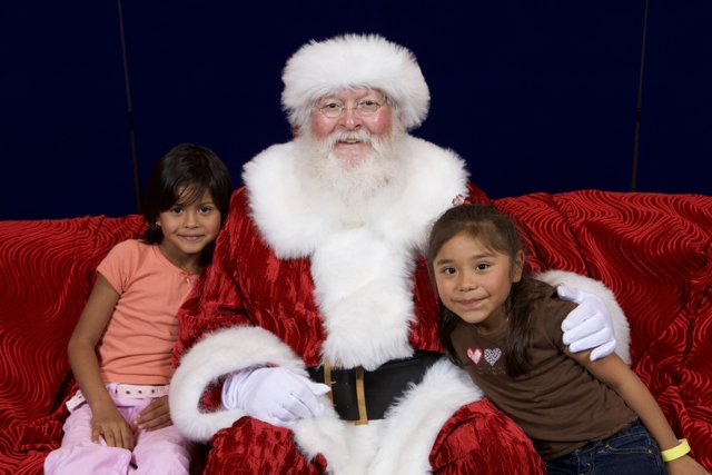 Santa Claus and Two Children on Red Couch