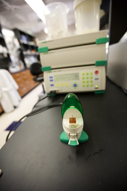 Small Green and White Device on Laboratory Table