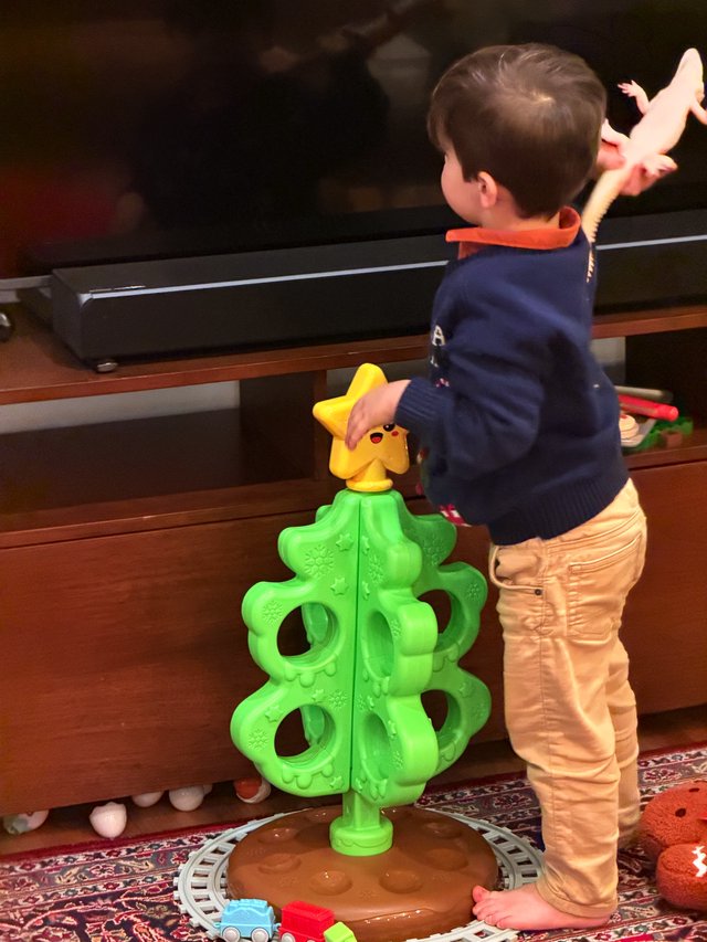 Toddler Playing with Bright Christmas Tree Toy
