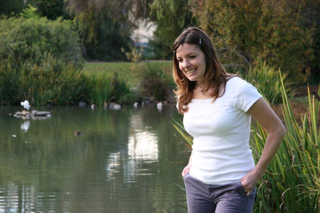 Smiling Woman by a Tranquil Park Pond