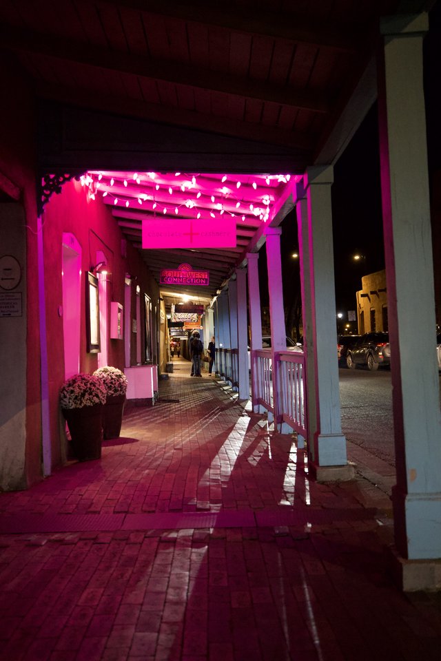 Pink-Lit Historic Storefront Corridor at Night
