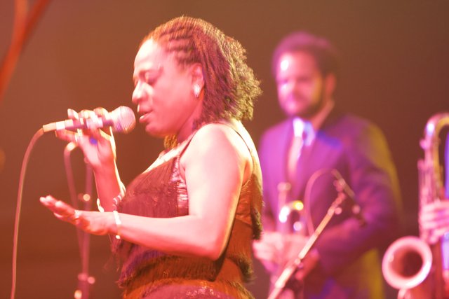 Concert Performance: Woman Singing and Man Playing Saxophone
