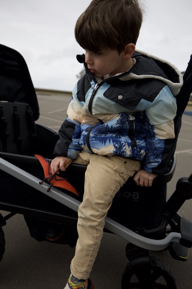 Young Boy Climbing onto Truck at Parking Lot